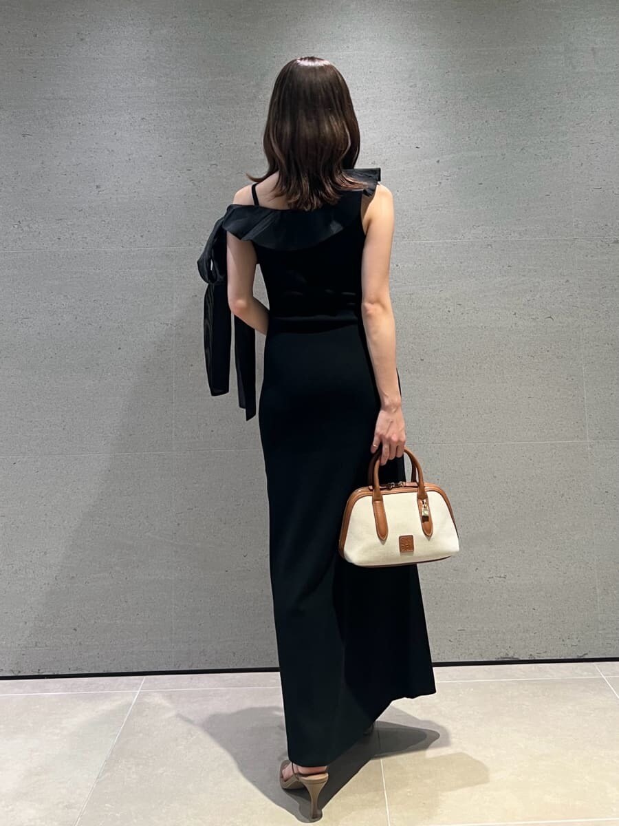 ブラック系のワンピース、イエロー系のボストンバッグ、ベージュ系のサンダルを着用したレディースの夏コーディネートの5枚目の写真