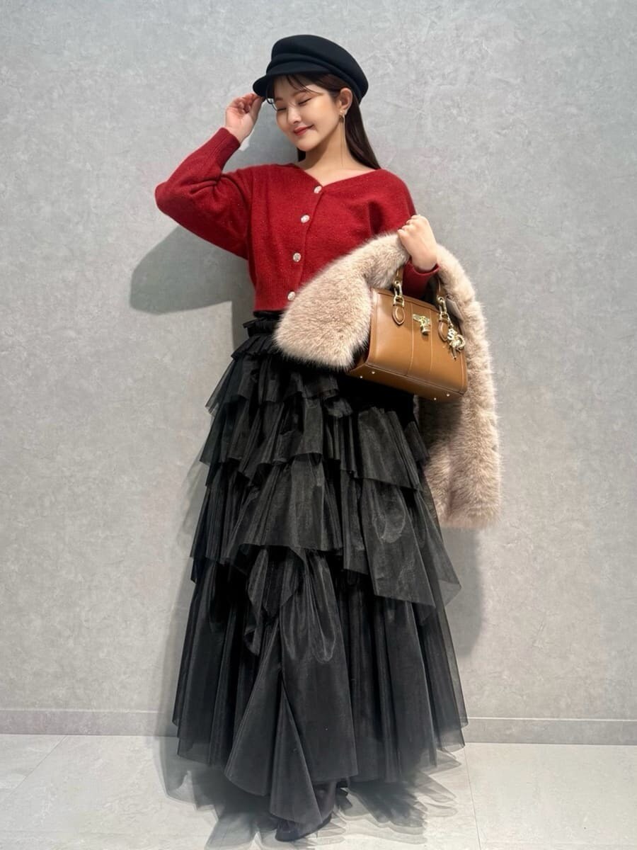 レッド系のブーツ、レッド系のカーディガン/ボレロ、ブラウン系のハンドバッグを着用したレディースの冬コーディネートの5枚目の写真