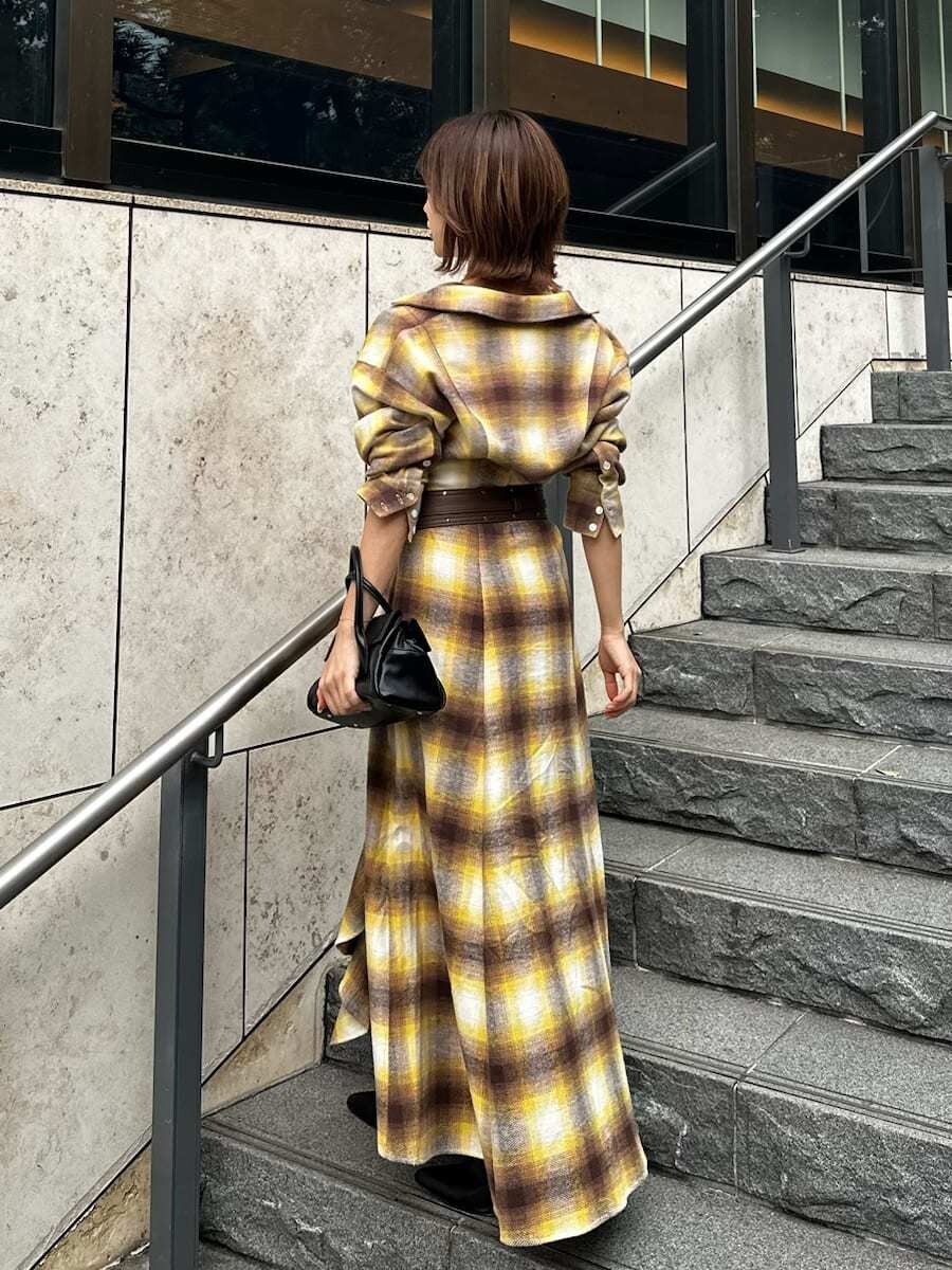 ブラック系のボストンバッグ、ホワイト系のピアス（両耳用）、ブラウン系のベルトを着用したレディースの冬コーディネートの6枚目の写真