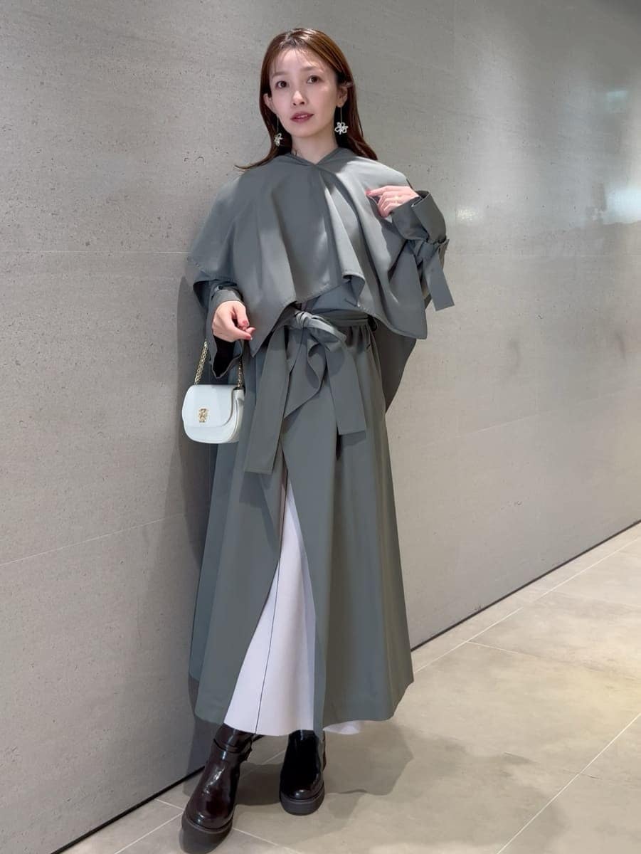 ホワイト系のワンピース、グリーン系のトレンチコート、ホワイト系のショルダーバッグを着用したレディースの冬コーディネートの4枚目の写真