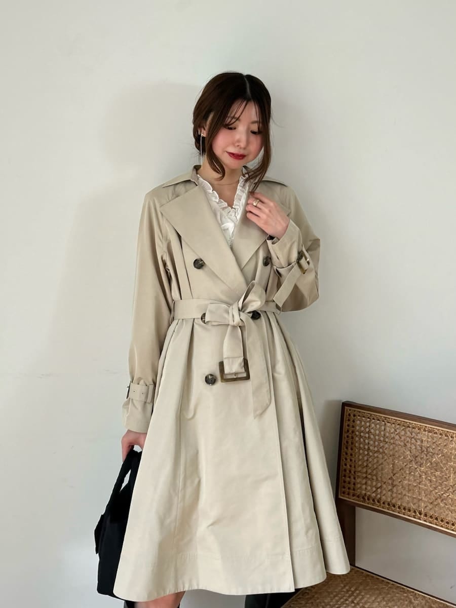 ブラック系のブーツ、ホワイト系のその他トップス、ベージュ系のトレンチコートを着用したレディースの春コーディネートの9枚目の写真