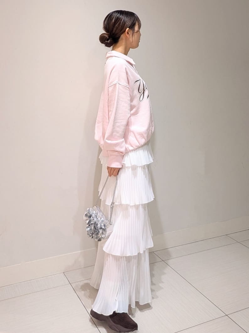 ホワイト系のスカート、ピンク系のスウェット、シルバー系のハンドバッグを着用したレディースの春コーディネートの2枚目の写真