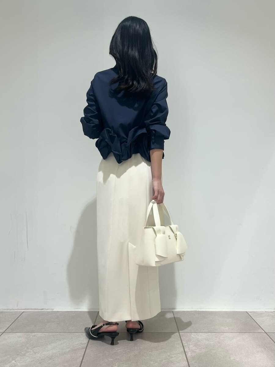 ホワイト系のスカート、ブルー系のシャツ/ブラウス、ブラック系のパンプスを着用したレディースの冬コーディネートの3枚目の写真