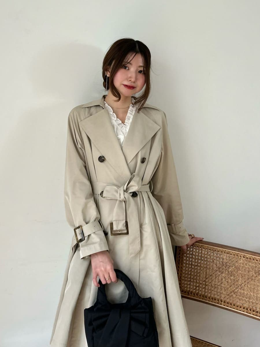 ブラック系のブーツ、ホワイト系のその他トップス、ベージュ系のトレンチコートを着用したレディースの春コーディネートの7枚目の写真