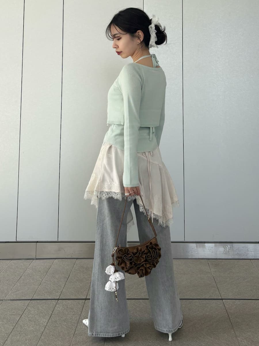 グレー系のデニムパンツ、ホワイト系のキャミソール、グリーン系のカーディガン/ボレロを着用したレディースの春コーディネートの6枚目の写真