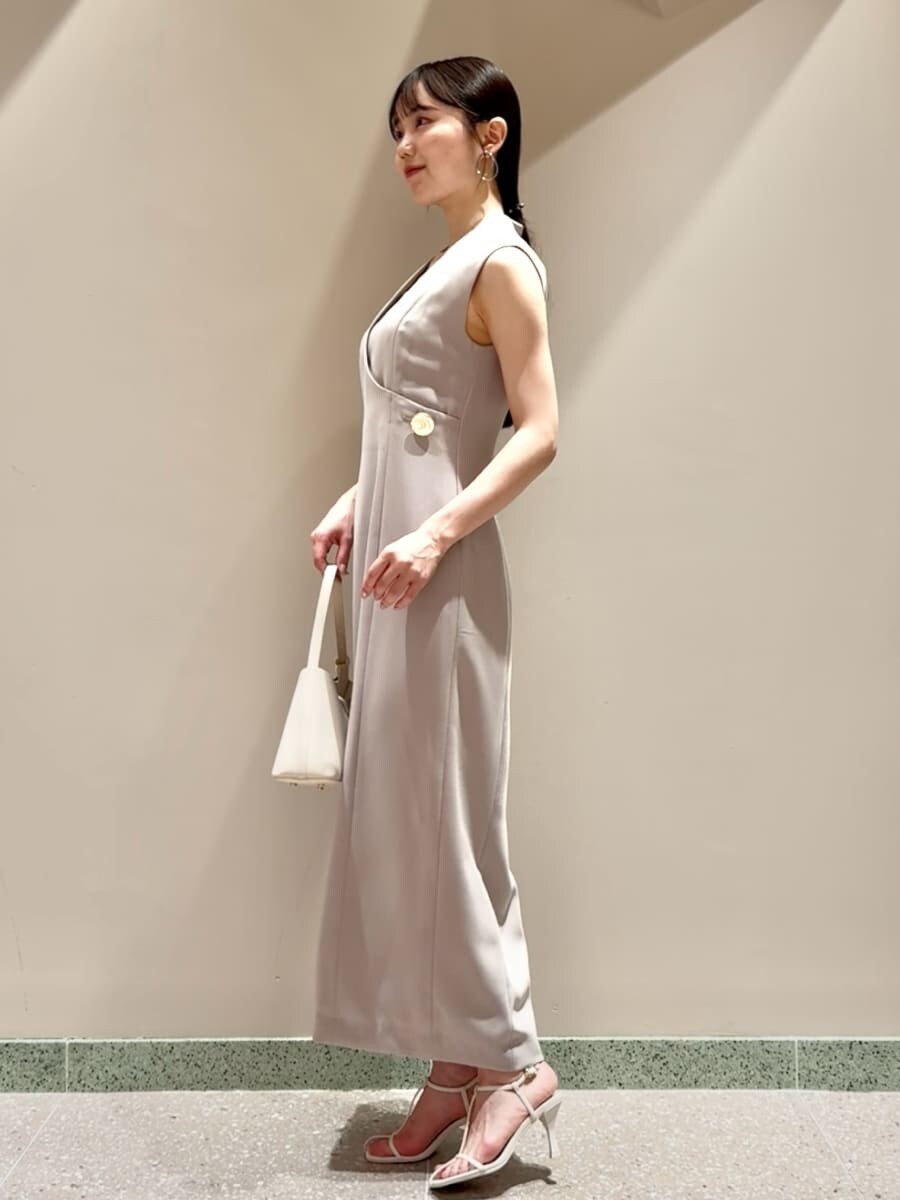 ベージュ系のワンピース、ホワイト系のサンダル、ホワイト系のハンドバッグを着用したレディースの夏コーディネートの2枚目の写真