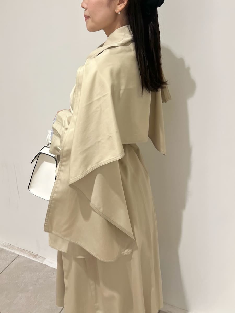 ブラウン系のブーツ、ベージュ系のトレンチコート、ホワイト系のハンドバッグを着用したレディースの冬コーディネートの6枚目の写真