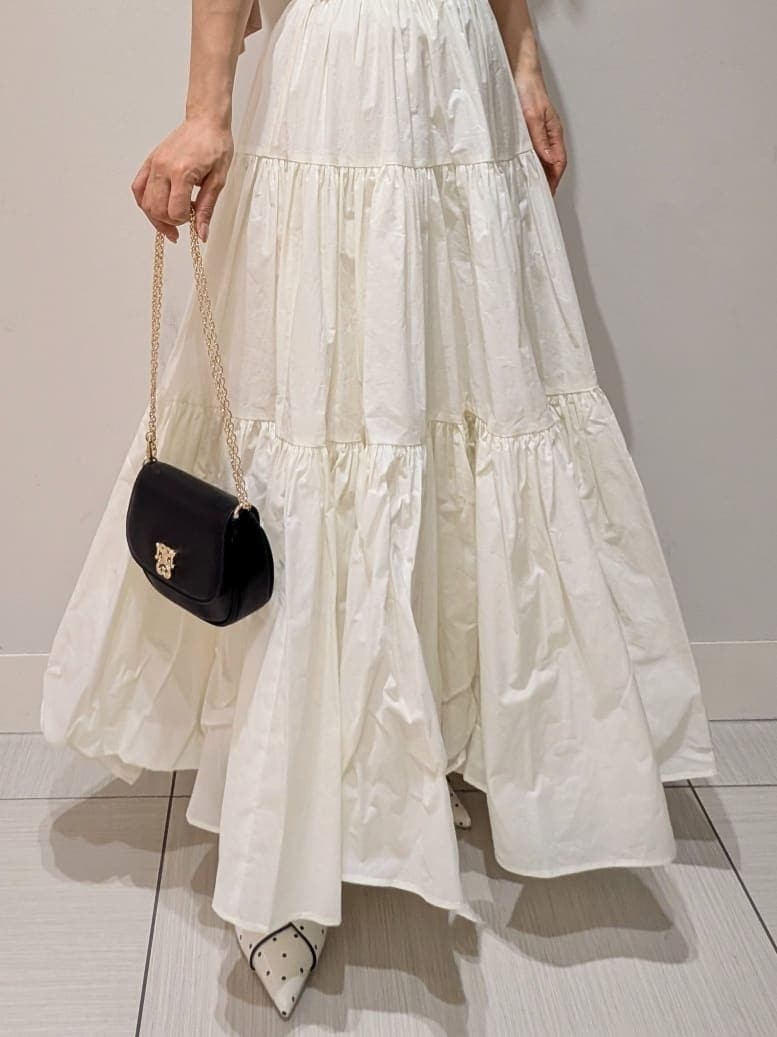 ホワイト系のスカート、その他のパンプス、ブラック系のショルダーバッグを着用したレディースの春コーディネートの5枚目の写真