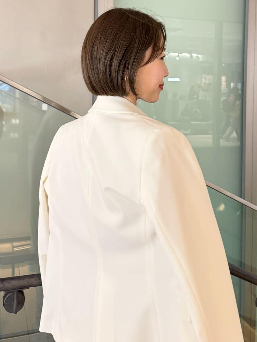 ピンク系のワンピース、ホワイト系のテーラードジャケット、ブラウン系のハンドバッグを着用したレディースの冬コーディネートの10枚目の写真