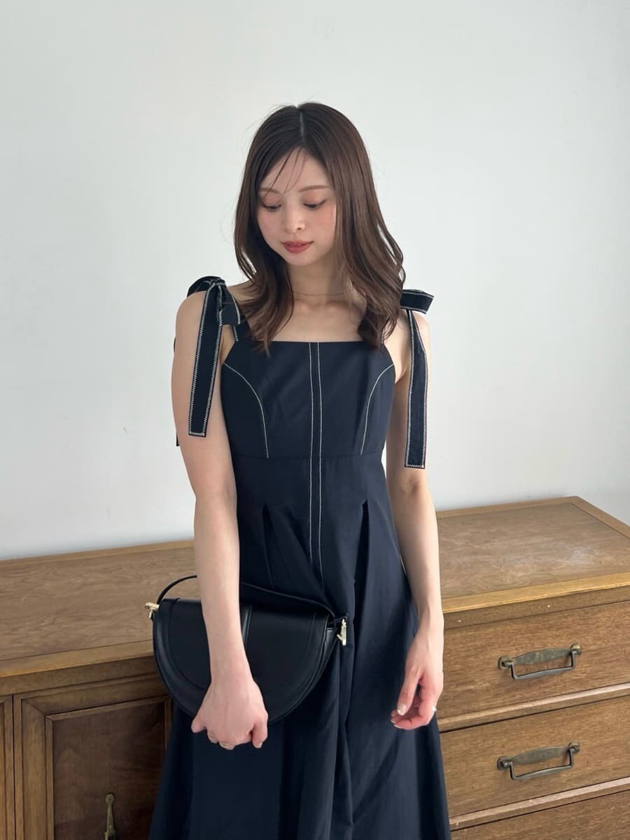 ブラック系のワンピース、ブラック系のハンドバッグ、ブラウン系のブーツを着用したレディースの夏コーディネートの4枚目の写真