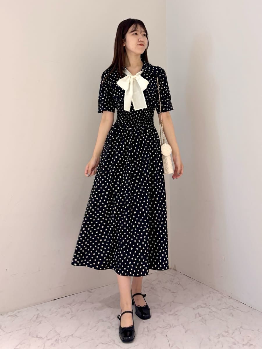 ブラック系のワンピース、ホワイト系のショルダーバッグ、ブラック系のパンプスを着用したレディースの夏コーディネートの4枚目の写真