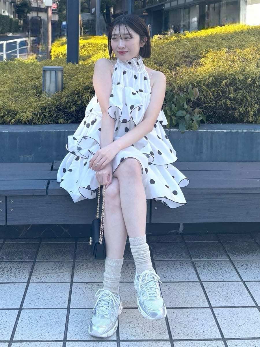 ホワイト系のワンピース、ブラック系のショルダーバッグ、シルバー系のスニーカーを着用したレディースの冬コーディネートの5枚目の写真