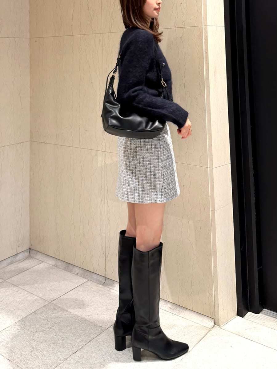 ブルー系のノーカラージャケット、ブルー系のスカート、ブラック系のブーツを着用したレディースの秋コーディネートの3枚目の写真