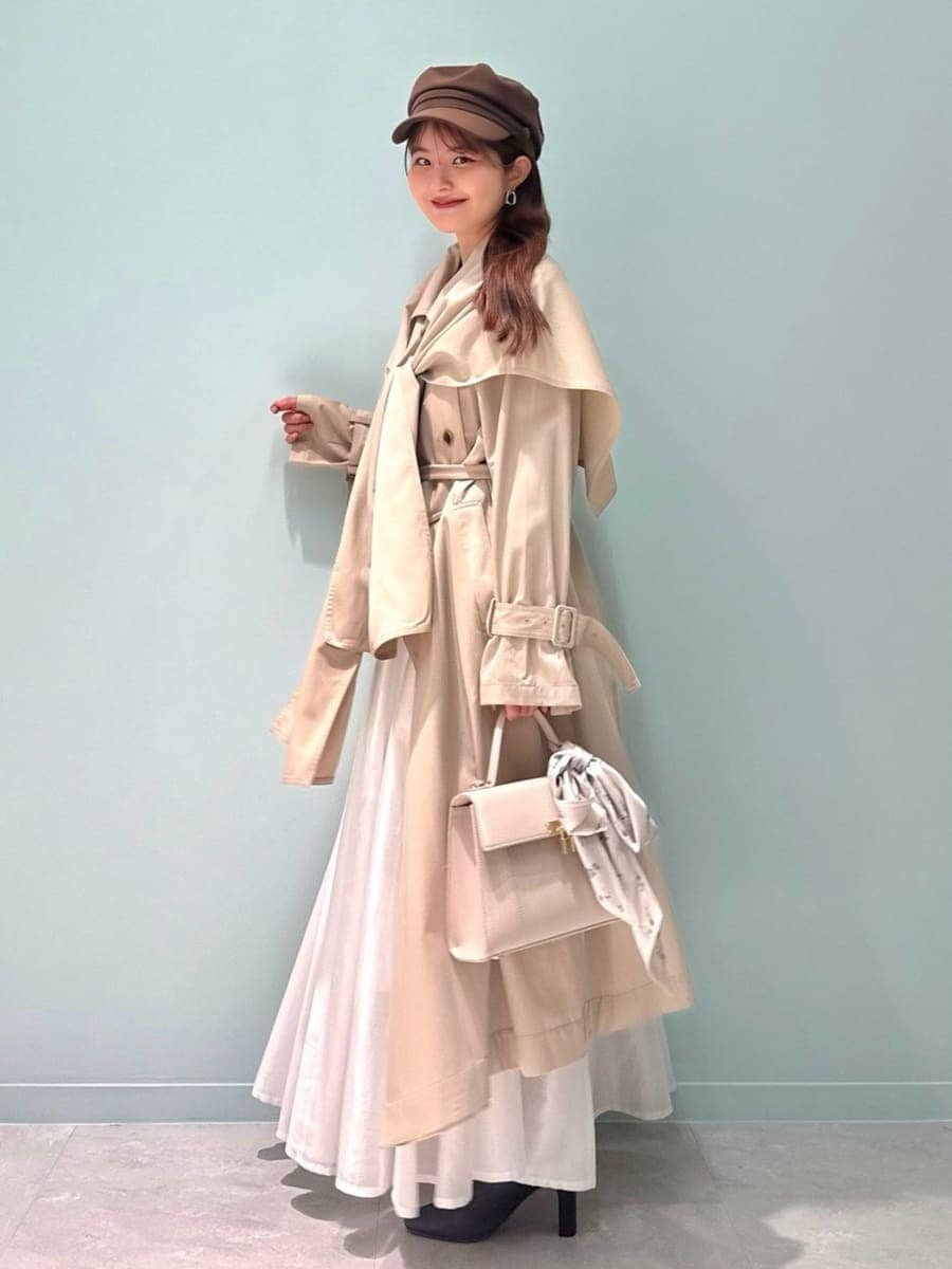 レッド系のブーツ、ベージュ系のトレンチコート、ベージュ系のハンドバッグを着用したレディースの冬コーディネートの8枚目の写真