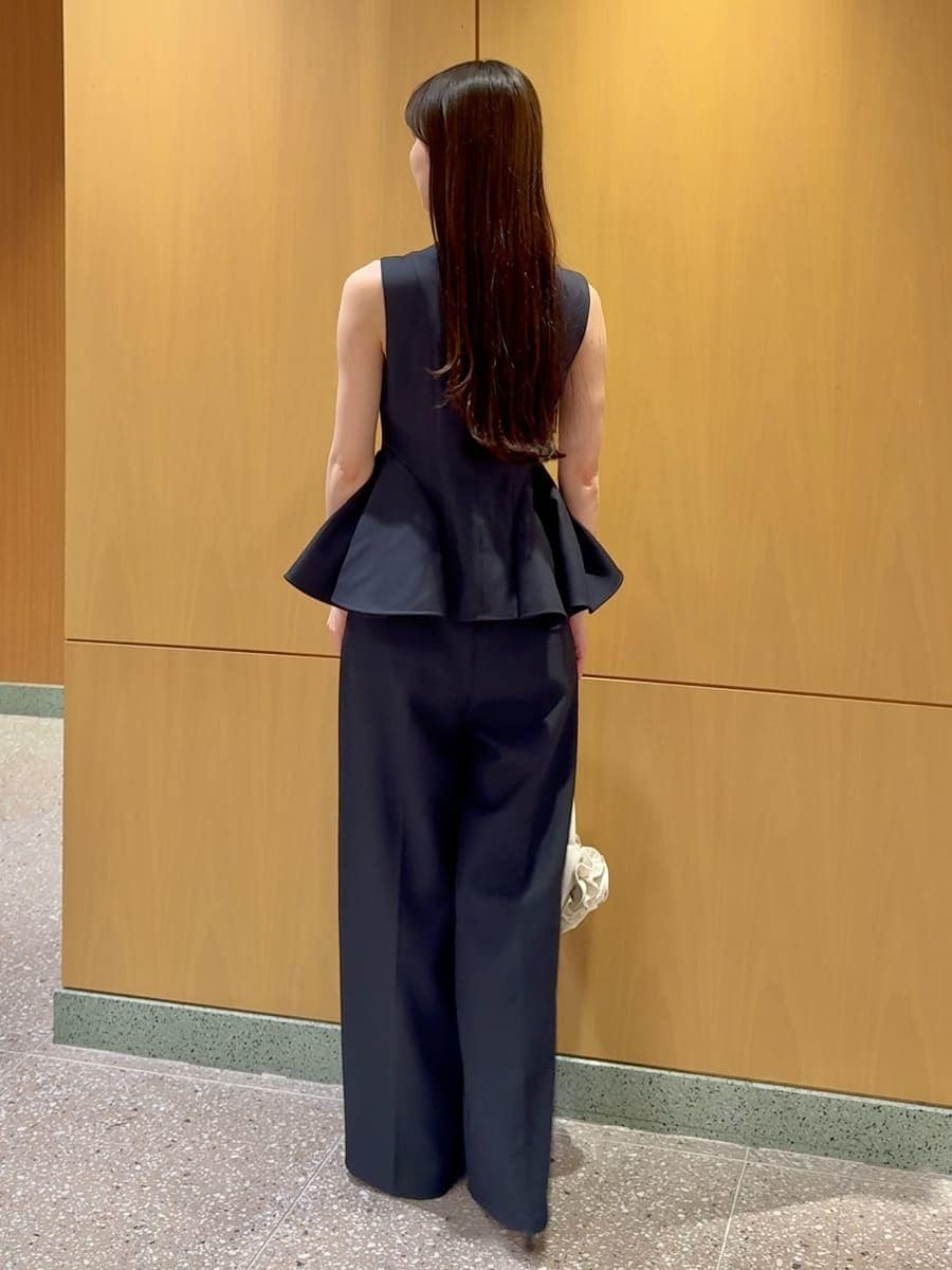 ブルー系のワンピース、ブラック系のパンプス、ホワイト系のハンドバッグを着用したレディースの春コーディネートの3枚目の写真
