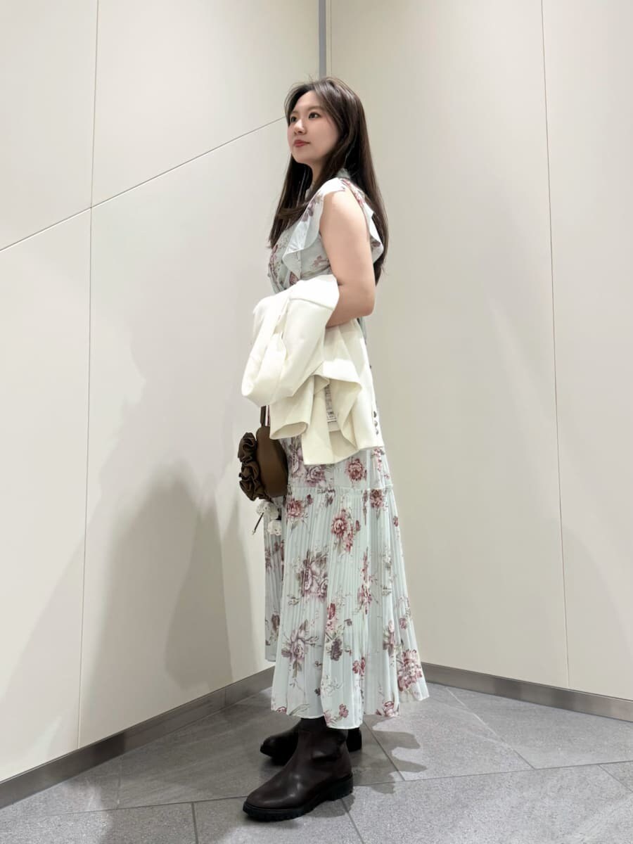 グリーン系のワンピースを着用したレディースの春コーディネートの3枚目の写真