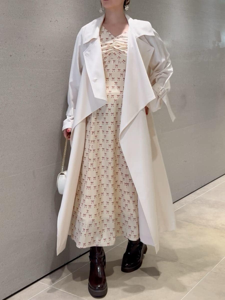 ホワイト系のトレンチコート、ベージュ系のワンピース、ホワイト系のショルダーバッグを着用したレディースの冬コーディネートの10枚目の写真