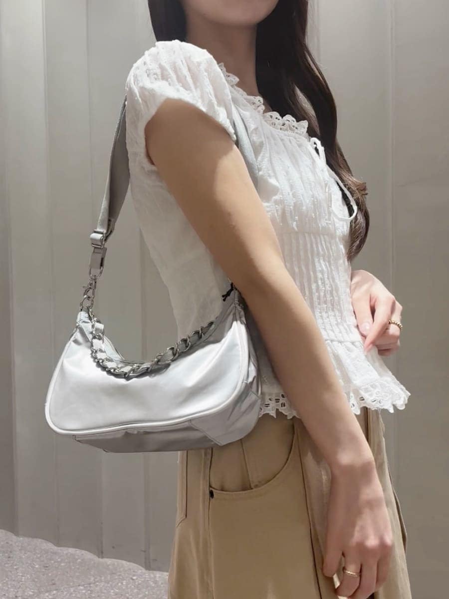 ベージュ系のスカート、ホワイト系のシャツ/ブラウス、シルバー系のショルダーバッグを着用したレディースの春コーディネートの5枚目の写真