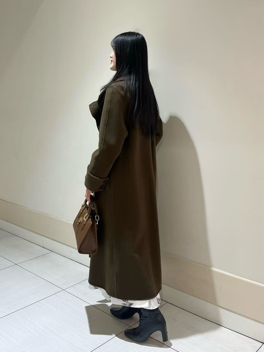 ブラック系のブーツ、ブラウン系のハンドバッグ、ブラウン系のチェスターコートを着用したレディースの冬コーディネートの2枚目の写真