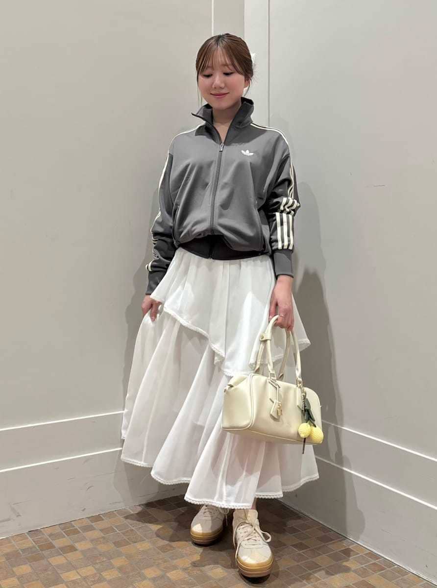 ホワイト系のスカート、ホワイト系のボストンバッグ、その他のスニーカーを着用したレディースの春コーディネートの2枚目の写真