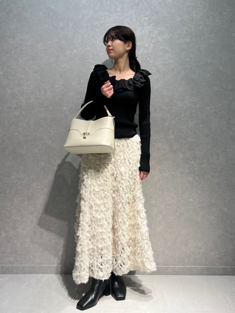 ホワイト系のスカート、ブラック系のニット/セーター、ホワイト系のハンドバッグを着用したレディースの冬コーディネートの4枚目の写真