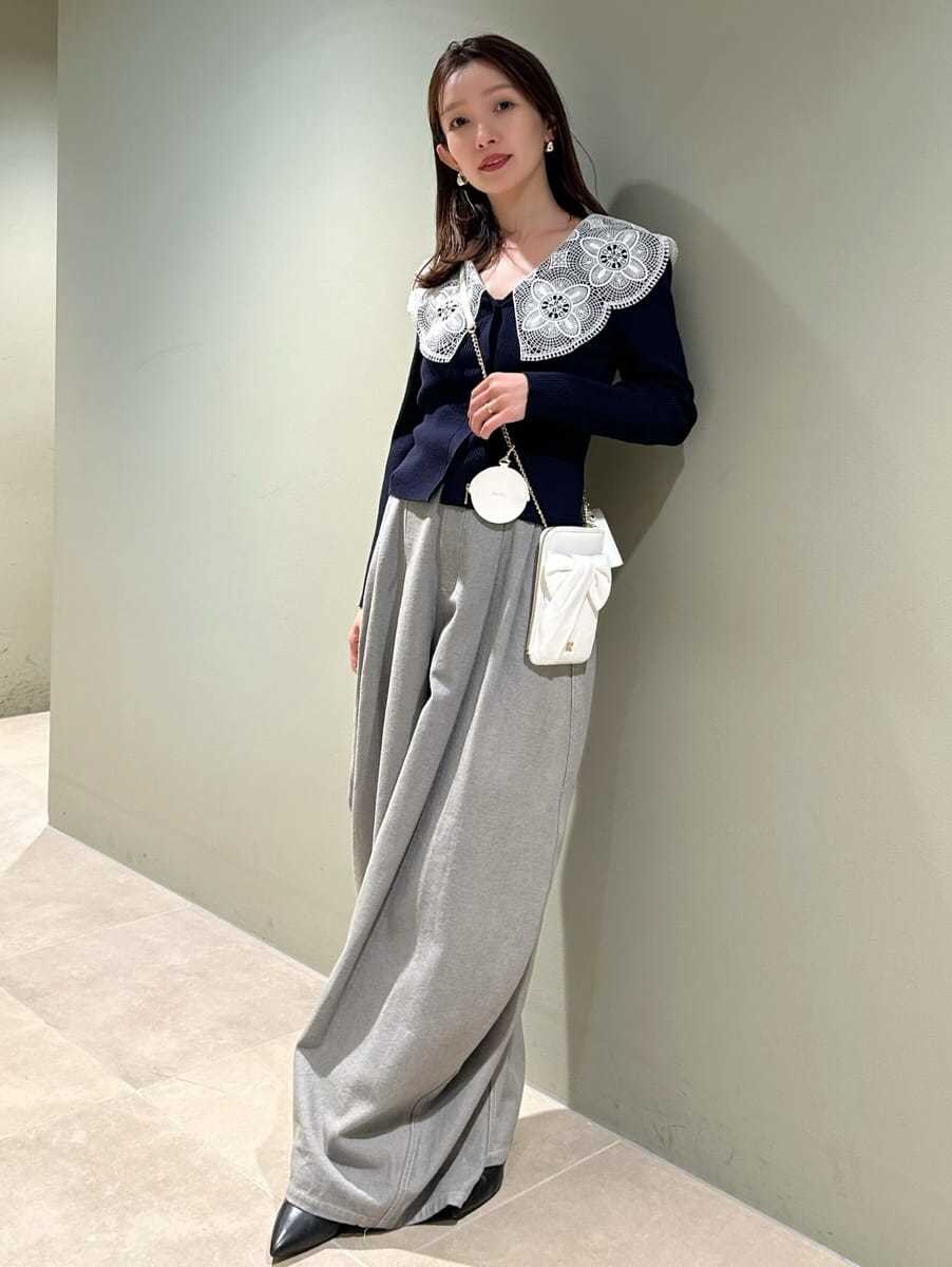 ブルー系のニット/セーター、グレー系のデニムパンツ、ホワイト系のショルダーバッグを着用したレディースの冬コーディネートの3枚目の写真