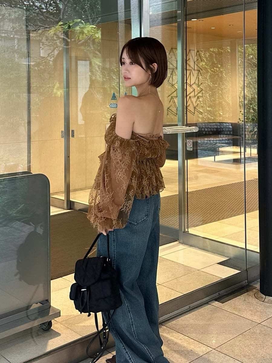ブルー系のデニムパンツ、イエロー系のシャツ/ブラウス、ブラウン系のサンダルを着用したレディースの秋コーディネートの3枚目の写真
