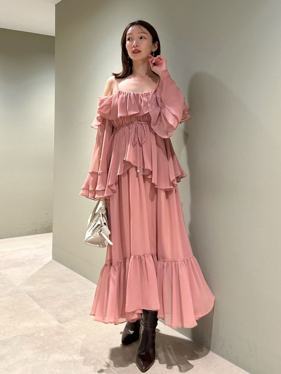 ブラウン系のブーツ、オレンジ系のワンピース、ホワイト系のボストンバッグを着用したレディースの冬コーディネートの2枚目の写真