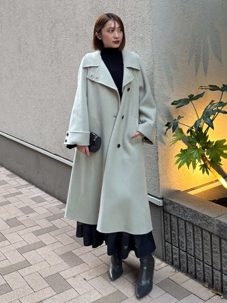 グレー系のブーツ、グリーン系のチェスターコート、ブラック系のワンピースを着用したレディースの秋コーディネートの3枚目の写真