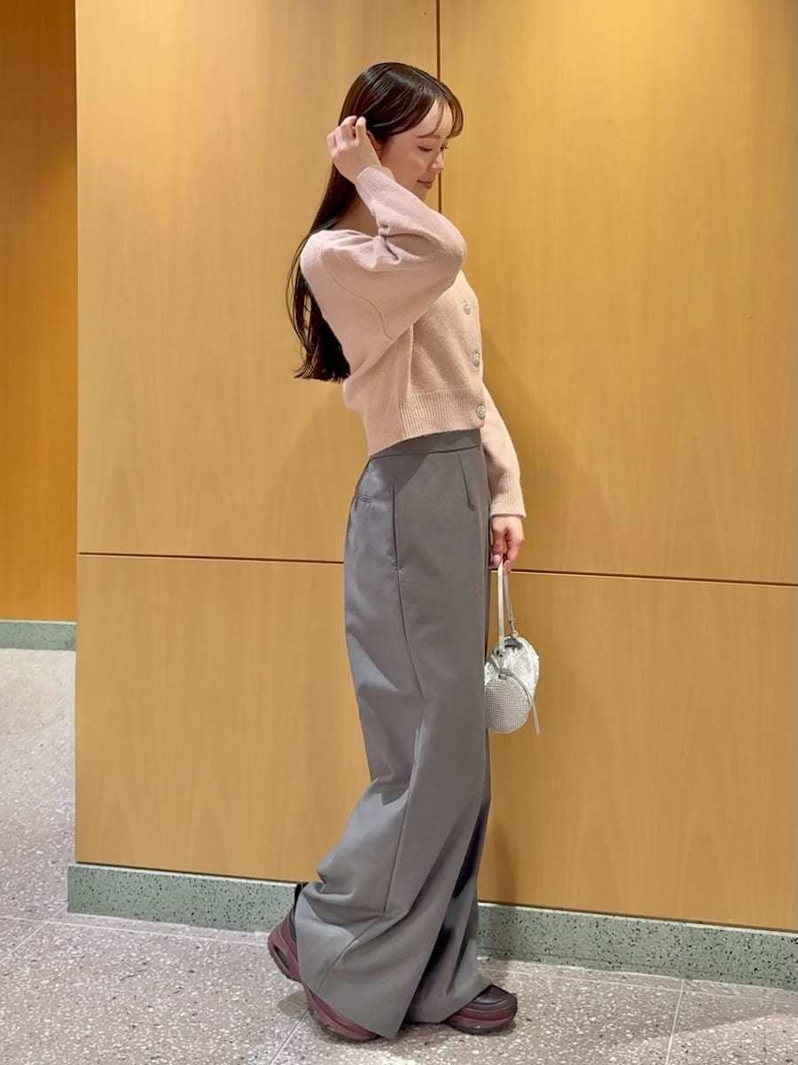 グレー系のスラックス、ピンク系のカーディガン/ボレロを着用したレディースの冬コーディネートの2枚目の写真