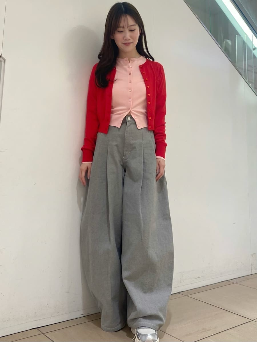 グレー系のデニムパンツ、レッド系のカーディガン/ボレロ、シルバー系のスニーカーを着用したレディースの冬コーディネートの5枚目の写真