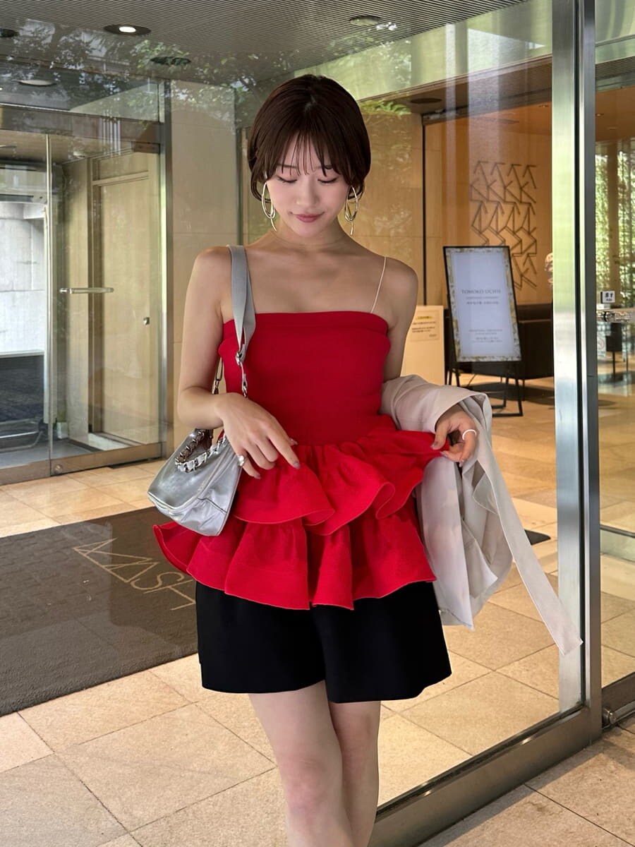 ブラック系のその他パンツ、レッド系のニット/セーター、シルバー系のショルダーバッグを着用したレディースの春コーディネートの2枚目の写真