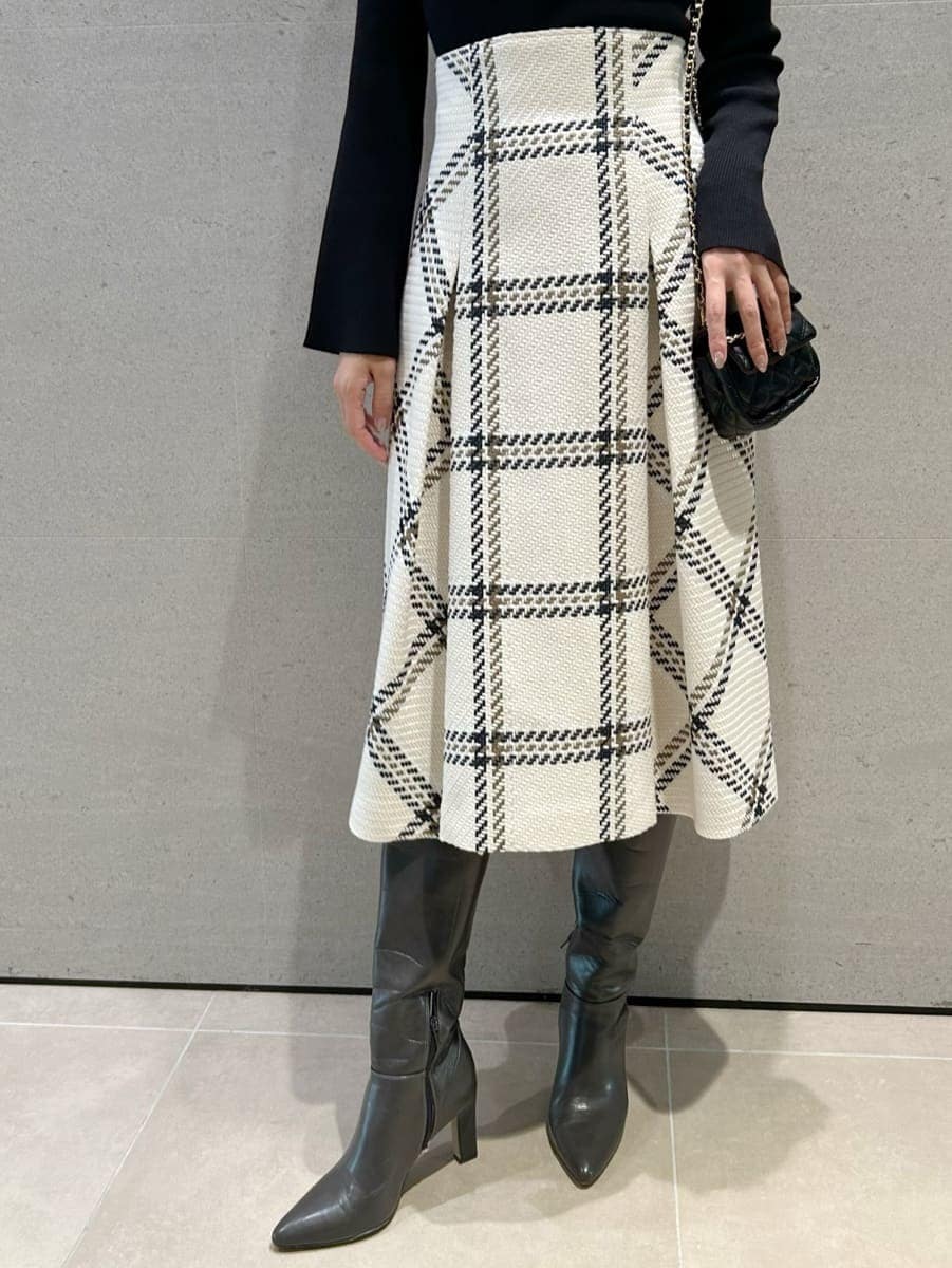 ブラック系のニット/セーター、ホワイト系のスカート、グレー系のブーツを着用したレディースの秋コーディネートの3枚目の写真