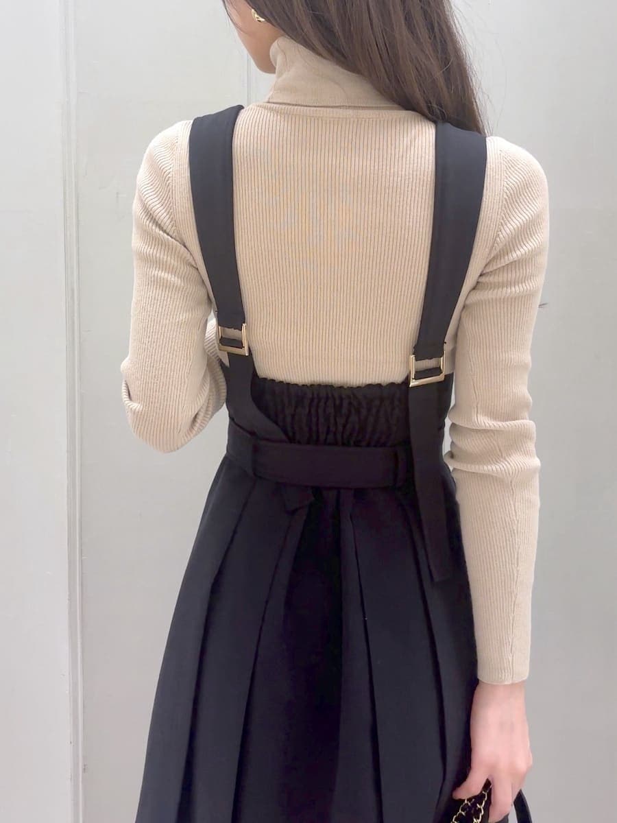 ブラック系のワンピース、ベージュ系のニット/セーター、ブラック系のブーツを着用したレディースの秋コーディネートの7枚目の写真