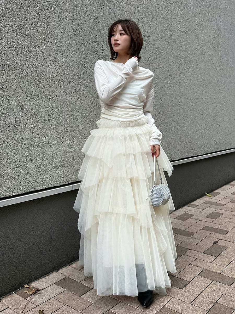 ブラック系のブーツ、ホワイト系のニット/セーター、その他のピアス（両耳用）を着用したレディースの冬コーディネートの2枚目の写真