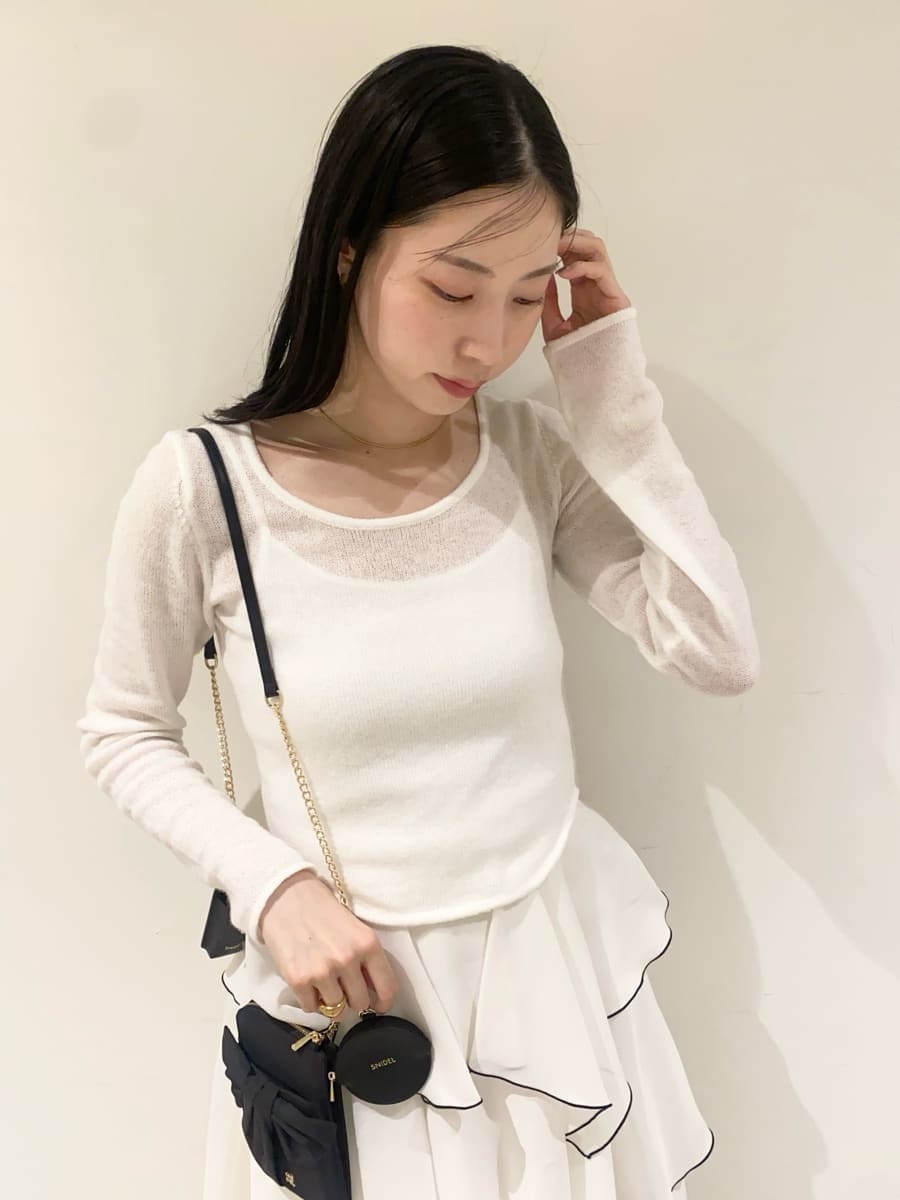 ホワイト系のワンピース、ブラック系のショルダーバッグ、シルバー系のスニーカーを着用したレディースの冬コーディネートの5枚目の写真