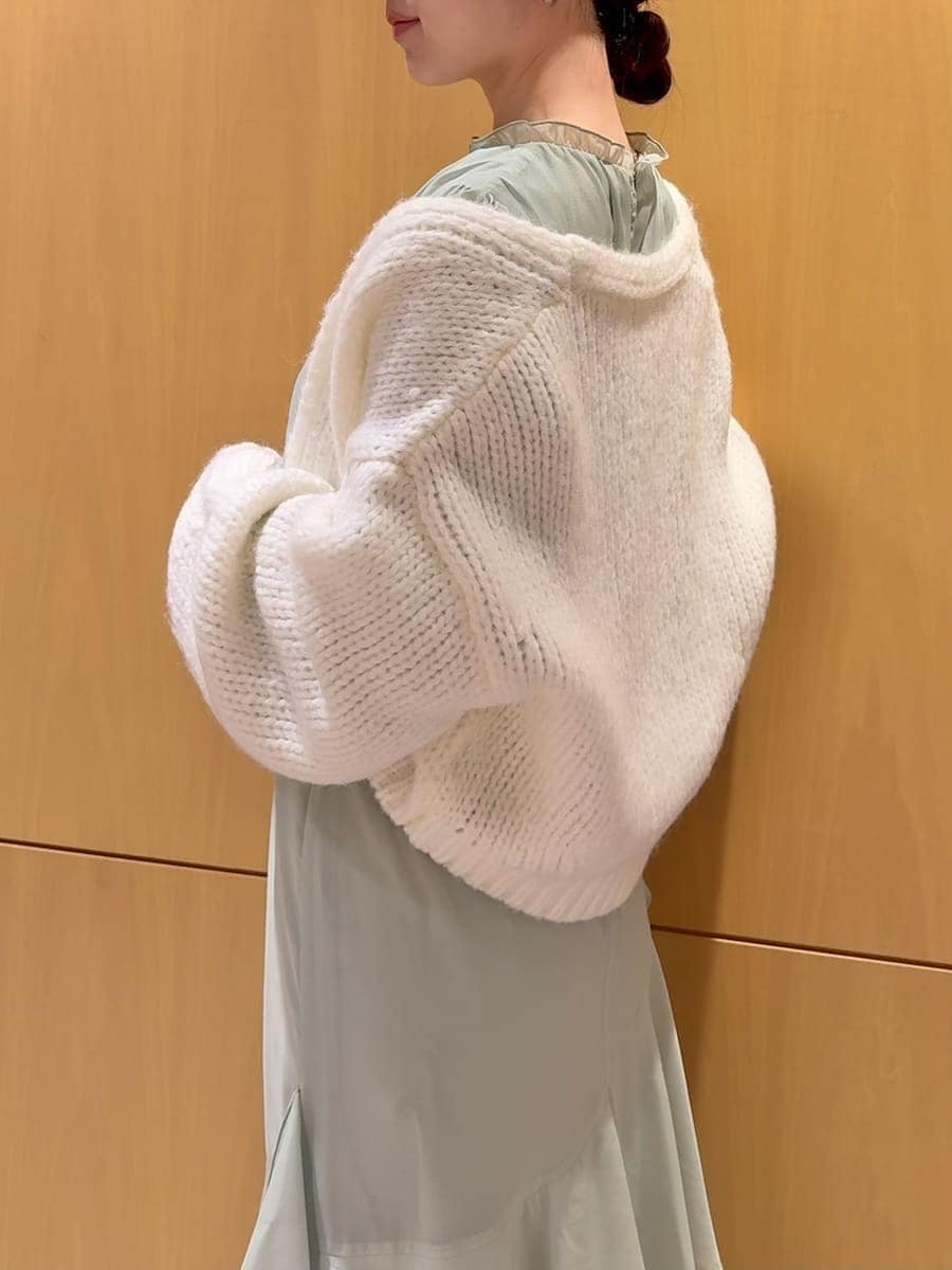 グリーン系のワンピース、ホワイト系のカーディガン/ボレロを着用したレディースの冬コーディネートの7枚目の写真