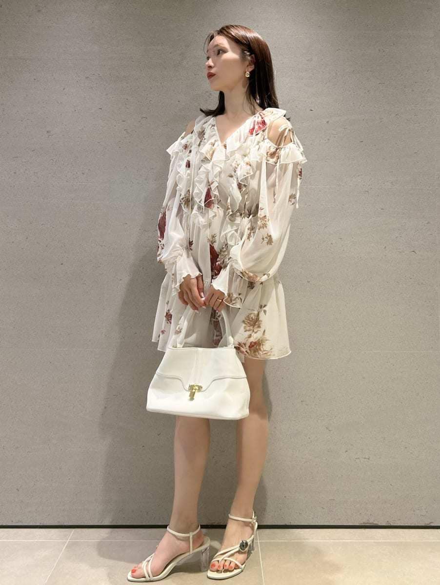 ホワイト系のハンドバッグを着用したレディースの春コーディネートの2枚目の写真