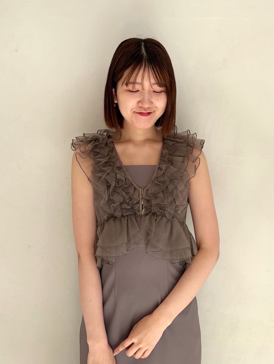 ベージュ系のハンドバッグ、グレー系のドレスを着用したレディースの春コーディネートの4枚目の写真