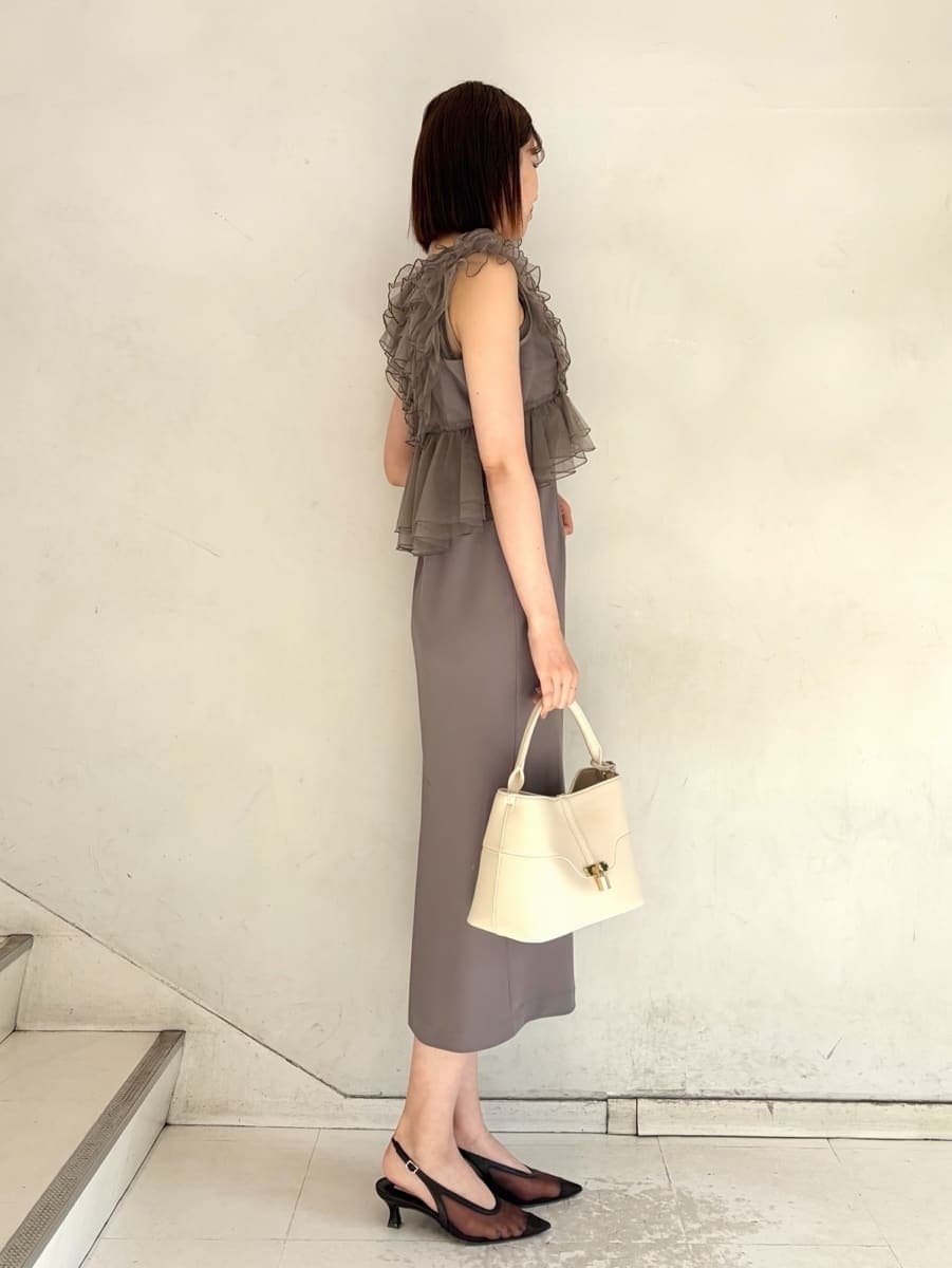 ベージュ系のハンドバッグ、グレー系のドレスを着用したレディースの春コーディネートの3枚目の写真