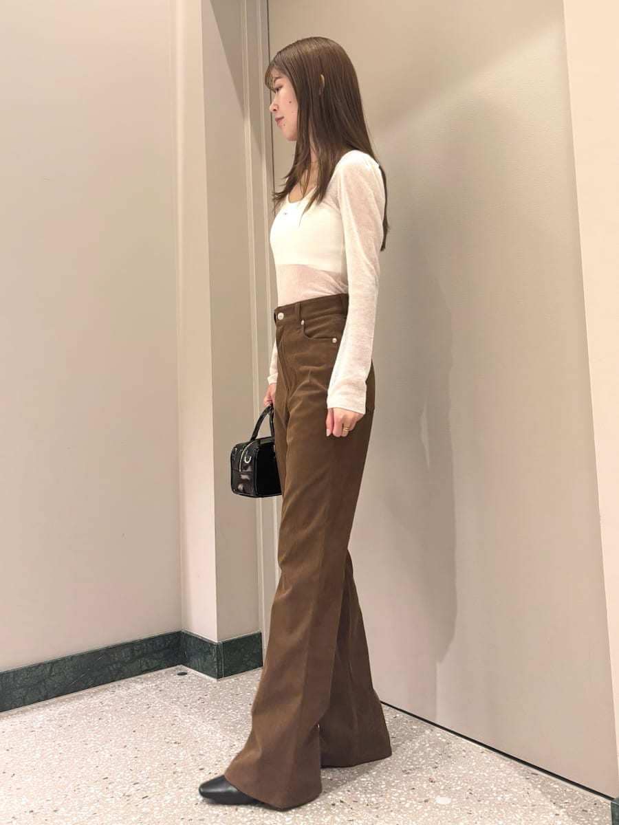 ホワイト系のニット/セーター、ブラウン系のその他パンツ、ブラック系のブーツを着用したレディースの秋コーディネートの3枚目の写真