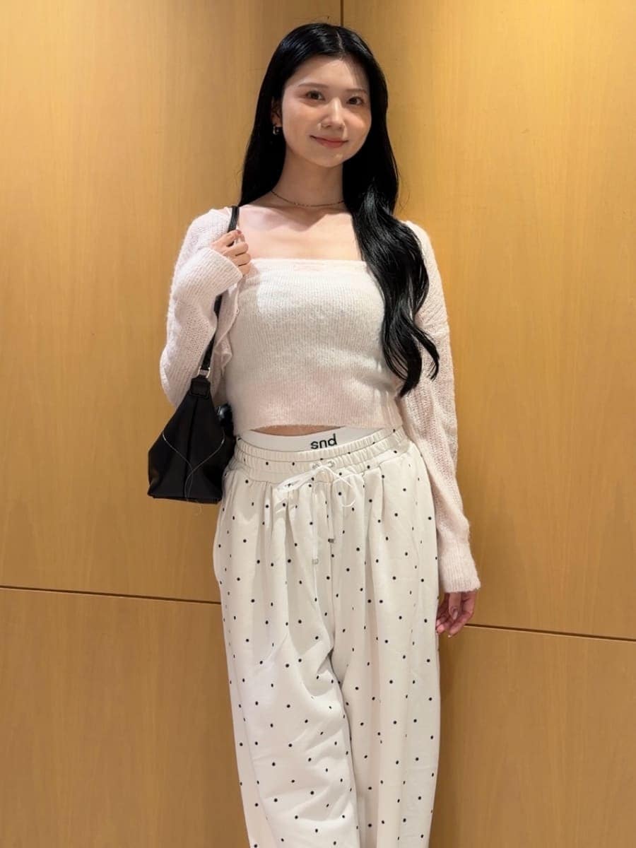 ピンク系のカーディガン/ボレロ、ブラック系のパンプス、ブラック系のショルダーバッグを着用したレディースの秋コーディネートの4枚目の写真