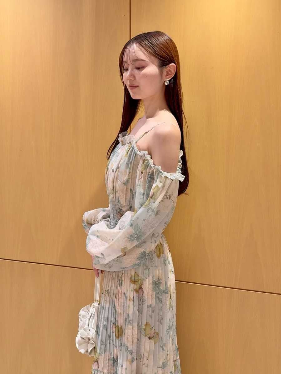 グリーン系のワンピース、ホワイト系のハンドバッグを着用したレディースの冬コーディネートの4枚目の写真