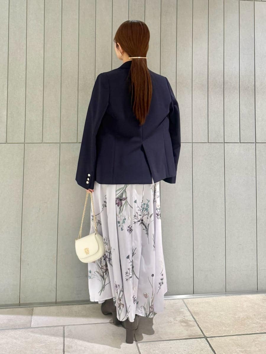ブルー系のテーラードジャケット、パープル系のワンピース、ホワイト系のショルダーバッグを着用したレディースの春コーディネートの2枚目の写真