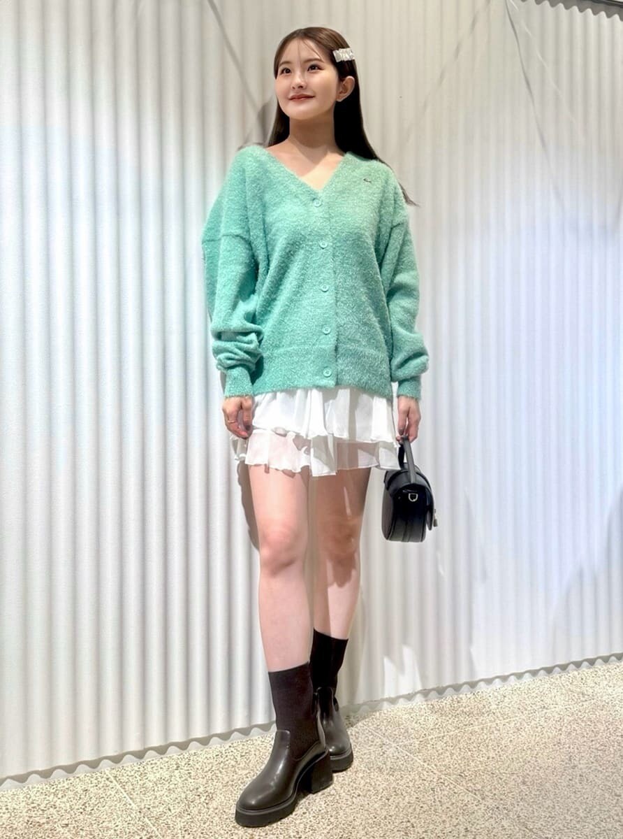 グリーン系のカーディガン/ボレロ、ホワイト系のその他パンツ、ブラック系のハンドバッグを着用したレディースの秋コーディネートの3枚目の写真