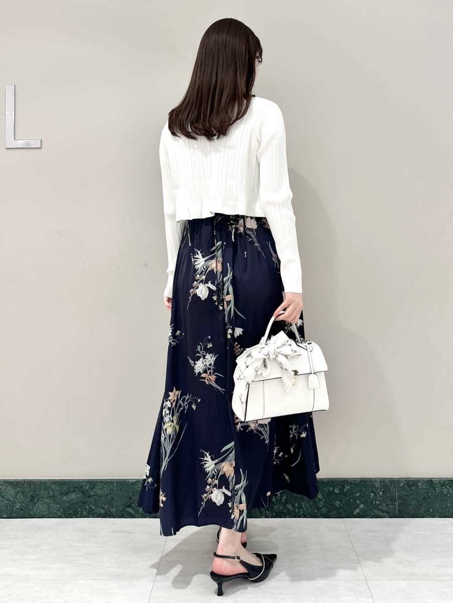 ホワイト系のカーディガン/ボレロ、ブルー系のワンピース、ブラック系のパンプスを着用したレディースの冬コーディネートの4枚目の写真