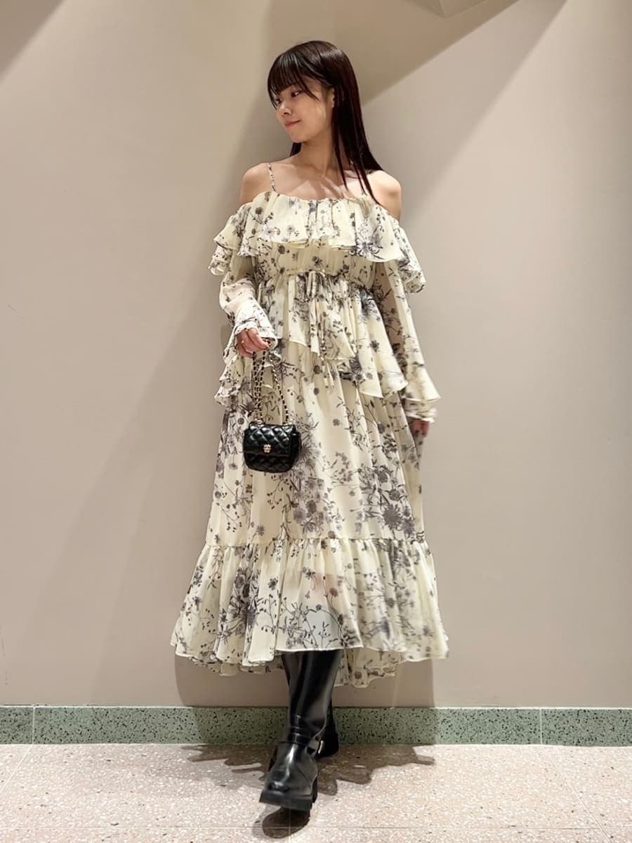 ホワイト系のブルゾン、イエロー系のワンピース、ブラック系のブーツを着用したレディースの秋コーディネートの7枚目の写真