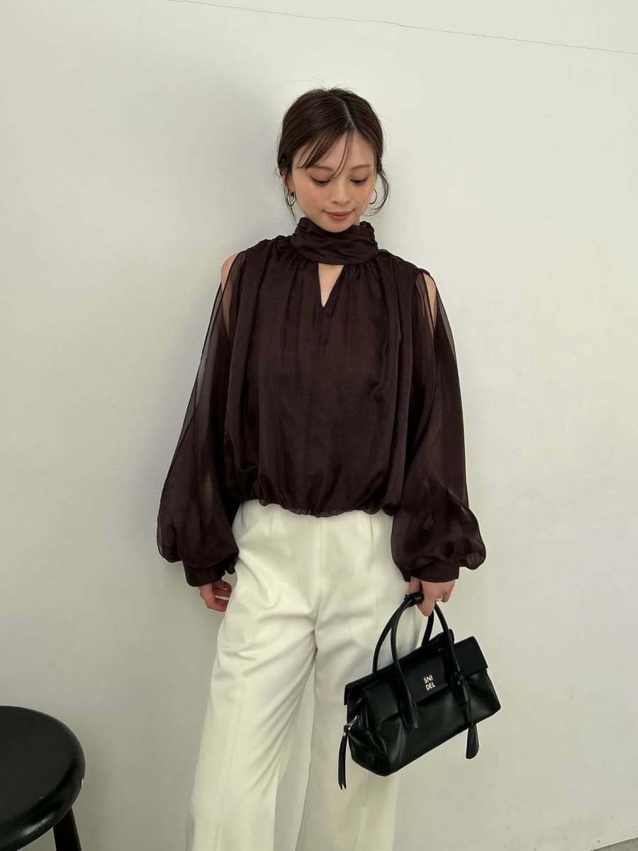 ブラック系のブーツ、ホワイト系のスラックス、ブラウン系のシャツ/ブラウスを着用したレディースの秋コーディネートの4枚目の写真