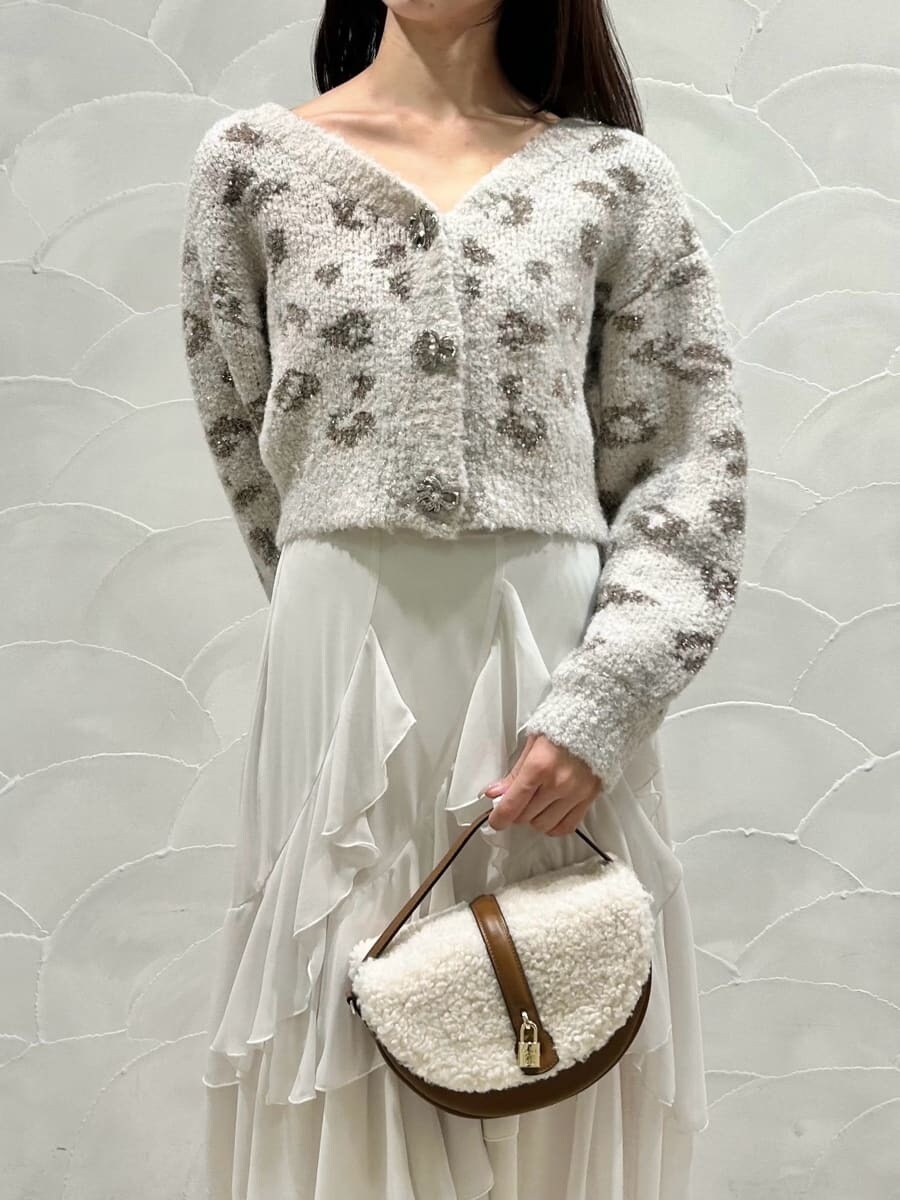 レッド系のブーツ、イエロー系のハンドバッグ、ホワイト系のスカートを着用したレディースの秋コーディネートの6枚目の写真