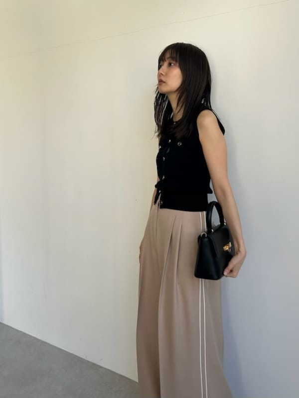 ブラック系のニット/セーター、ベージュ系のその他パンツ、ブラック系のショルダーバッグを着用したレディースの春コーディネートの6枚目の写真